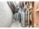 Unfinished basement with water heater, pipes, and concrete wall at 12388 E Caspian Dr, Aurora, CO 80014