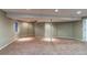 Open basement space with carpeting and a support beam at 12388 E Caspian Dr, Aurora, CO 80014