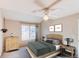 Cozy bedroom featuring a ceiling fan, a neutral palette, and a large window for natural light at 12388 E Caspian Dr, Aurora, CO 80014