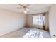 Simple, sunlit bedroom featuring neutral carpet, and a window overlooking trees at 12388 E Caspian Dr, Aurora, CO 80014