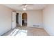 Spacious bedroom with neutral walls, a ceiling fan, and an archway to an attached bathroom at 12388 E Caspian Dr, Aurora, CO 80014