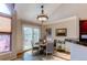 Cozy dining area with a round table, elegant chandelier, and access to outdoor area with bar cart at 12388 E Caspian Dr, Aurora, CO 80014