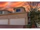 Charming townhome featuring a two-car garage and beautiful landscaping under a vibrant sunset sky at 12388 E Caspian Dr, Aurora, CO 80014