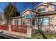 Charming exterior view with multiple windows, a red fence, and a small outdoor patio at 12388 E Caspian Dr, Aurora, CO 80014