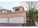 Exterior view of a two-car garage with a brick driveway and neutral-colored stucco at 12388 E Caspian Dr, Aurora, CO 80014