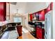 Stylish kitchen featuring granite countertops, red cabinets, and stainless steel appliances at 12388 E Caspian Dr, Aurora, CO 80014
