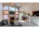 Inviting living room with a fireplace, large windows, and an adjacent dining area with stylish decor at 12388 E Caspian Dr, Aurora, CO 80014