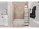 A bathroom including a white shower/tub combination with a shower curtain and adjacent washer/dryer at 30 Fox St, Denver, CO 80223