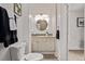 A bathroom featuring a neutral vanity, round mirror, and a toilet at 30 Fox St, Denver, CO 80223