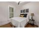 A bedroom with a white bed, hardwood floors, and black and gold accents at 30 Fox St, Denver, CO 80223