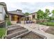 Charming home with stone pathway, garden beds, inviting porch with chairs, and well-maintained yard at 30 Fox St, Denver, CO 80223