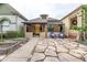Charming bungalow with a bright yellow door, stone patio, and lovely landscaping at 30 Fox St, Denver, CO 80223