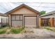 View of the detached garage with an weathered garage door and adjacent storage area at 30 Fox St, Denver, CO 80223