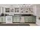 A kitchen featuring green cabinets, stainless steel appliances, track lighting, and open shelving at 30 Fox St, Denver, CO 80223