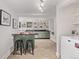 A kitchen with green cabinets, dark countertops, an island with seating and stainless steel appliances at 30 Fox St, Denver, CO 80223