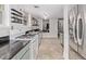 A kitchen view with green cabinets, stainless appliances, black countertops and open shelving at 30 Fox St, Denver, CO 80223