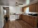 Kitchen with wood cabinets and white appliances. A dog is walking through the door at 8 S Kendall St, Lakewood, CO 80226