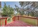Red stained wood deck and fenced yard, partially shaded by trees at 1824 S Granby St, Aurora, CO 80012