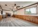 Finished basement area with carpet, wood paneling, brick fireplace, and bright windows at 1824 S Granby St, Aurora, CO 80012
