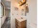 Bathroom featuring single sink vanity, toilet and view into an adjacent room at 1824 S Granby St, Aurora, CO 80012