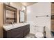 Modern bathroom featuring a double sink vanity with sleek gray cabinets and tiled shower at 1824 S Granby St, Aurora, CO 80012