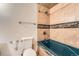 Bathroom featuring a blue bath tub, toilet and tiled wall with shower head at 1824 S Granby St, Aurora, CO 80012