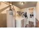 Laundry room with washer, dryer, and water heater. Door leads to bathroom at 1824 S Granby St, Aurora, CO 80012