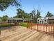 Wooden deck with a lawn, garden, shed, and the back of a house, surrounded by trees and fences at 3750 S Galapago St, Englewood, CO 80110