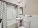 Neutral bathroom featuring a shower-tub combination and a pedestal sink, with white-paneled wainscoting at 3750 S Galapago St, Englewood, CO 80110