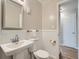 Compact bathroom featuring a pedestal sink, toilet, and view of the door with wood flooring at 3750 S Galapago St, Englewood, CO 80110