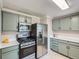 Well-lit kitchen with stainless steel appliances and charming green cabinets at 3750 S Galapago St, Englewood, CO 80110