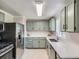 Updated kitchen featuring modern countertops, stainless steel appliances, and stylish green cabinetry at 3750 S Galapago St, Englewood, CO 80110