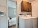 Laundry area including white appliances and cabinets, adjoining a bedroom view with a bed at 3750 S Galapago St, Englewood, CO 80110