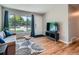 Well-lit living room with hardwood floors, a large window, and a modern entertainment center at 3750 S Galapago St, Englewood, CO 80110