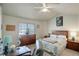 Cozy bedroom boasts a ceiling fan, a large window and matching wood furniture at 4120 E 119Th Pl # B, Thornton, CO 80233