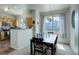 Bright dining area featuring a modern chandelier, neutral curtains and view of a well-kept kitchen at 4120 E 119Th Pl # B, Thornton, CO 80233