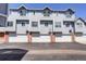 Exterior view of townhomes with white garage doors and gray siding at 4120 E 119Th Pl # B, Thornton, CO 80233