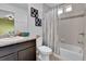 Bathroom featuring tub with shower, neutral tile and floors and a dark vanity at 5131 Andes St, Denver, CO 80249