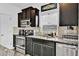 Well-equipped kitchen with stainless steel appliances, subway tile backsplash, and dark cabinets at 5131 Andes St, Denver, CO 80249