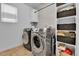 Updated laundry room featuring modern washer and dryer and built in storage shelves at 5131 Andes St, Denver, CO 80249