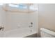 Bathroom featuring a bathtub with white tile walls and a window at 11010 Grayledge Cir, Highlands Ranch, CO 80130