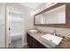 Bathroom with dual sinks, granite countertops, and stylish mirrors at 11010 Grayledge Cir, Highlands Ranch, CO 80130