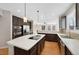 Spacious kitchen featuring an island with cooktop, stainless steel appliances, and tile backsplash at 11010 Grayledge Cir, Highlands Ranch, CO 80130