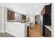 Bright kitchen with stainless steel appliances, pendant lighting, wooden floors, and extended countertop at 11010 Grayledge Cir, Highlands Ranch, CO 80130