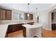 Kitchen with island cooktop, sleek white countertops, dark wood cabinets, and stainless steel appliances at 11010 Grayledge Cir, Highlands Ranch, CO 80130