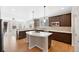 Well-lit kitchen featuring an island with bar seating, stainless steel appliances, and wooden floors at 11010 Grayledge Cir, Highlands Ranch, CO 80130