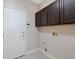 Mud room featuring white door with dark cabinets above washer and dryer hookups at 11010 Grayledge Cir, Highlands Ranch, CO 80130