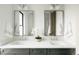 Bright bathroom featuring double sinks, stylish mirrors, modern fixtures, and sleek gray cabinetry at 1016 28Th St, Denver, CO 80205