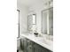 Bright bathroom featuring double sinks, stylish mirrors, modern fixtures, and sleek gray cabinetry at 1016 28Th St, Denver, CO 80205