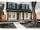 Charming two-story home with a black metal roof, covered porch, and landscaped front yard at 1016 28Th St, Denver, CO 80205